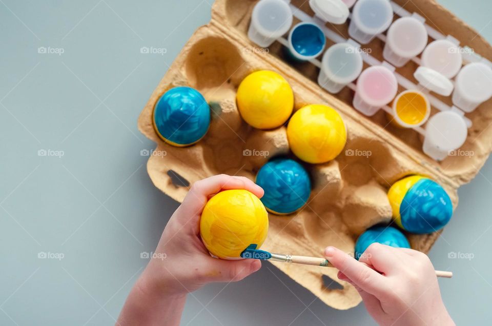 Little hands color Easter eggs.