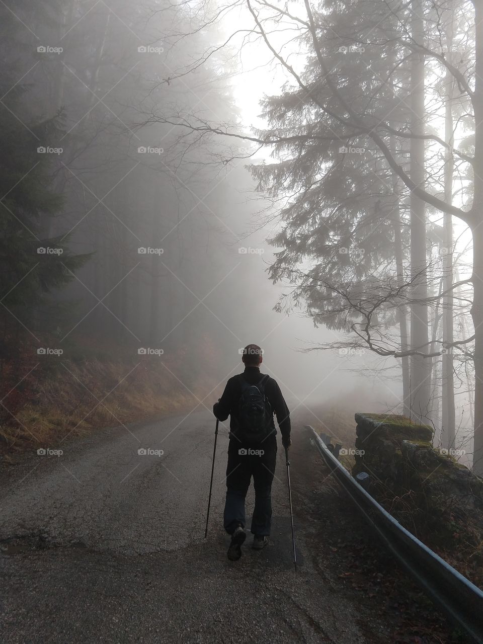 man walking in woods during misty winter morning