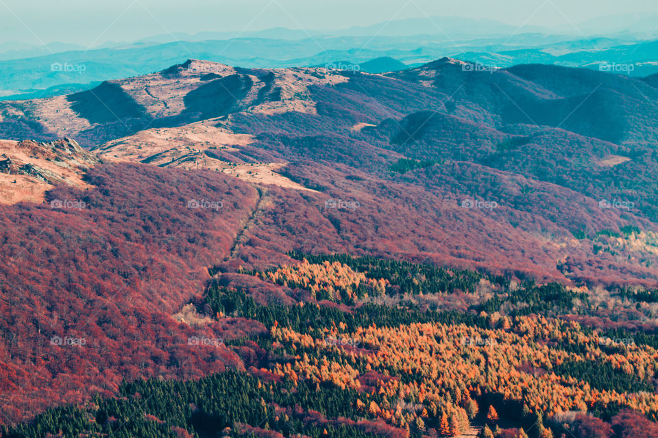 Autumn in The Bieszczady Mountains in Poland. Hillsides coloured with green, yellow, red, brown. Fall scenery, mountain landscape view from distance