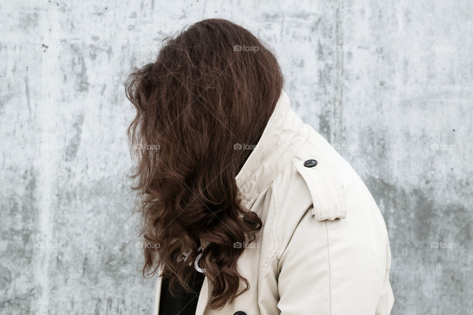 Young woman looking at a gray wall
