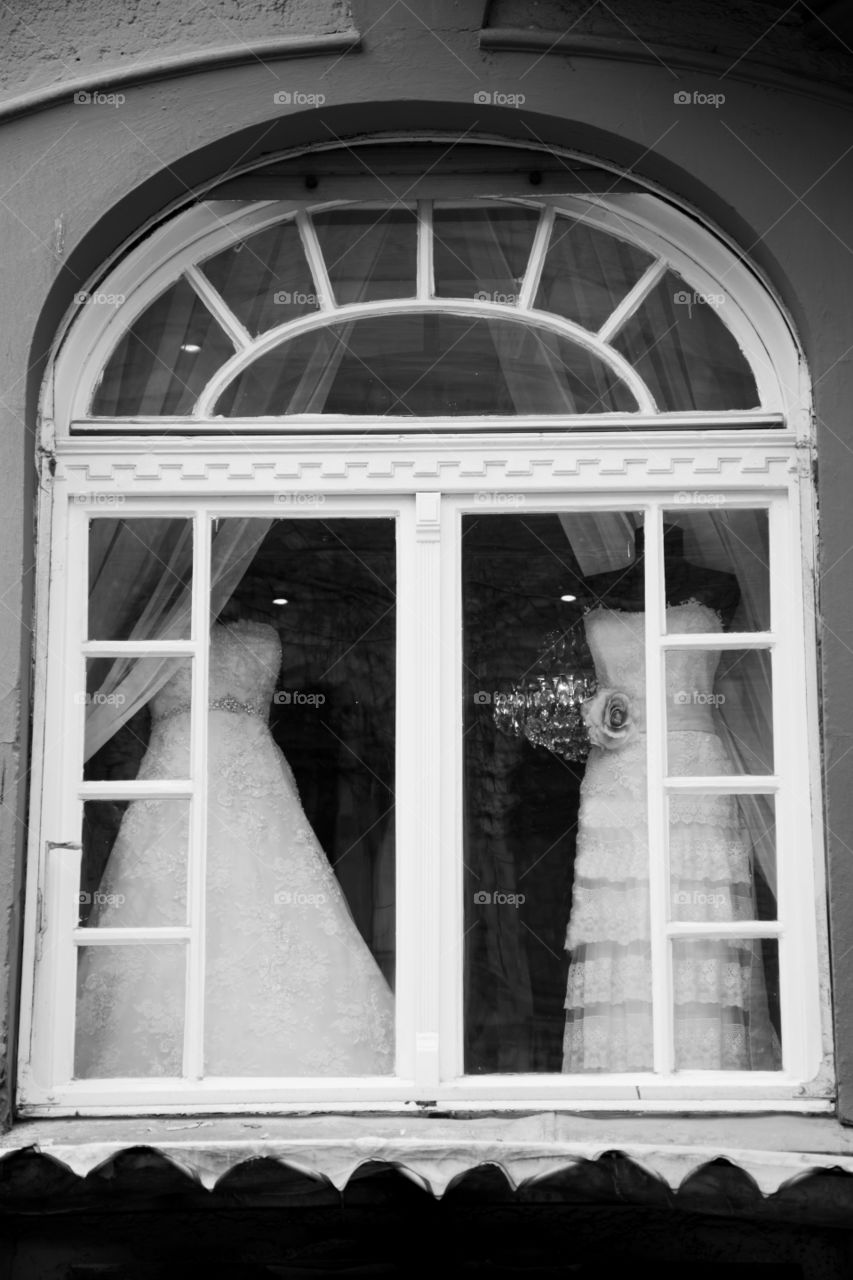 dresses in window. wedding dresses in beautiful architectural window