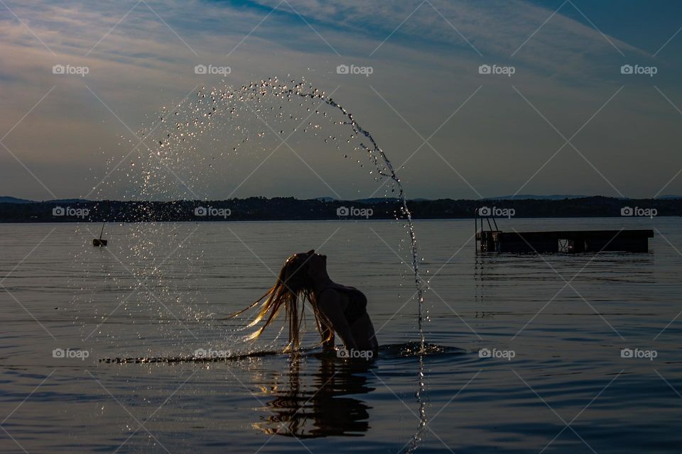 woman makes art into the water a Sunny day at the beach . 
she has a lot of fun and its beautiful woman mermaid.