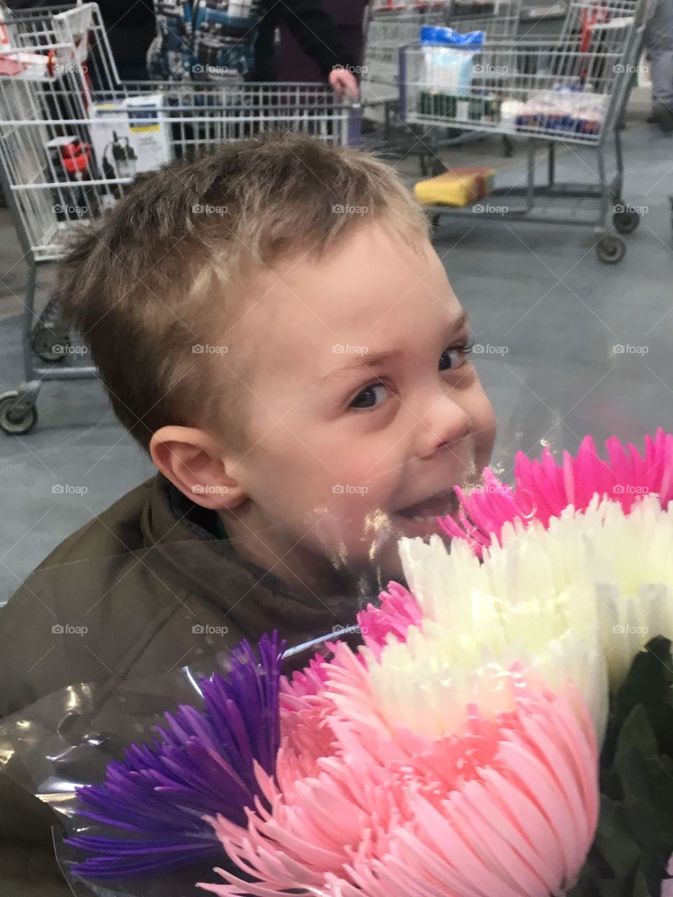 Toddler smelling flowers at the store 