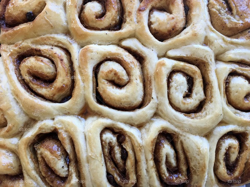 Fresh baked maple syrup glazed cinnamon rolls scrolls closeup