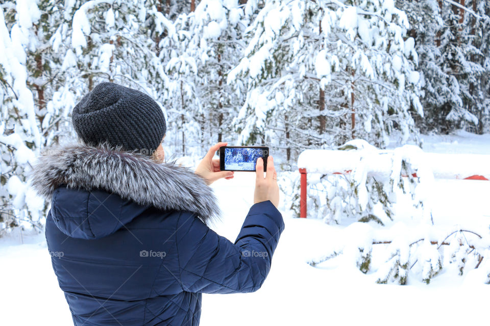girl take a photo in winter Forest