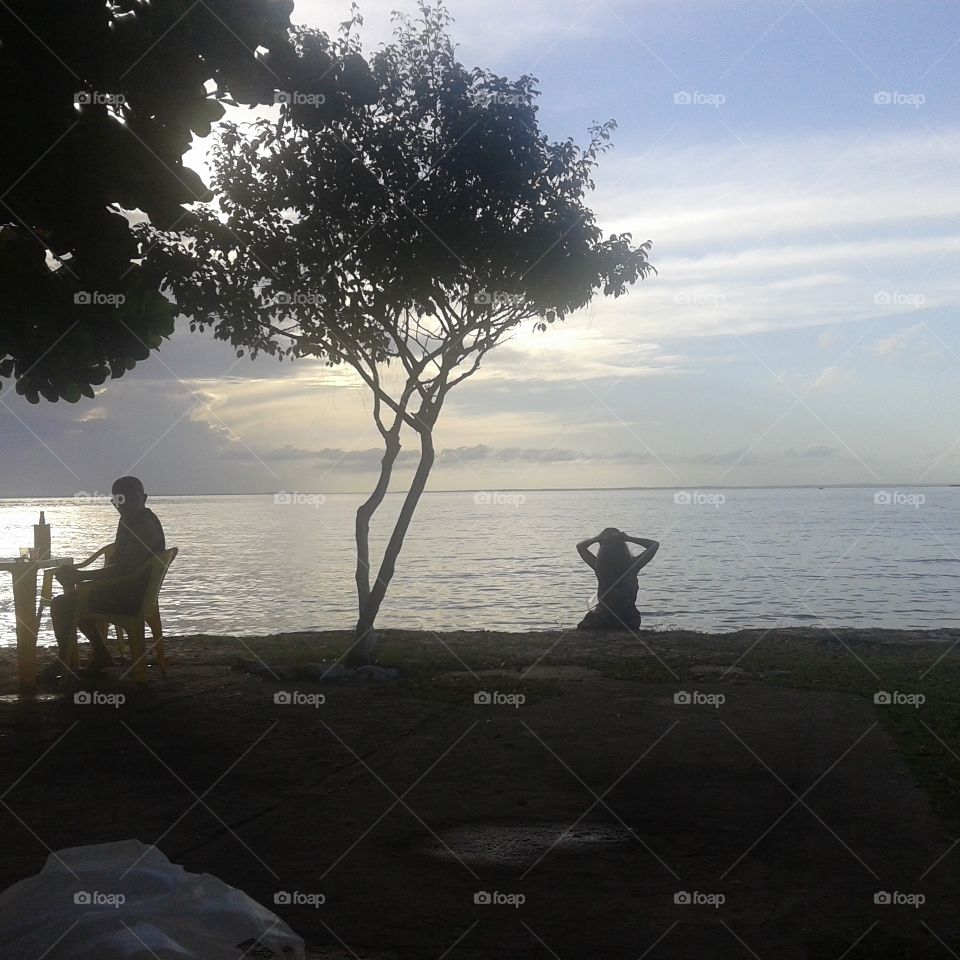 Pessoa sentada e contemplando o horizonte na Praia Grande em São Luís.