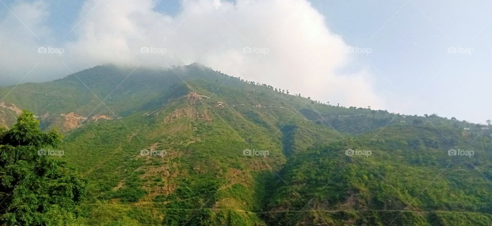Monsoon clouds emerging from behind the hills