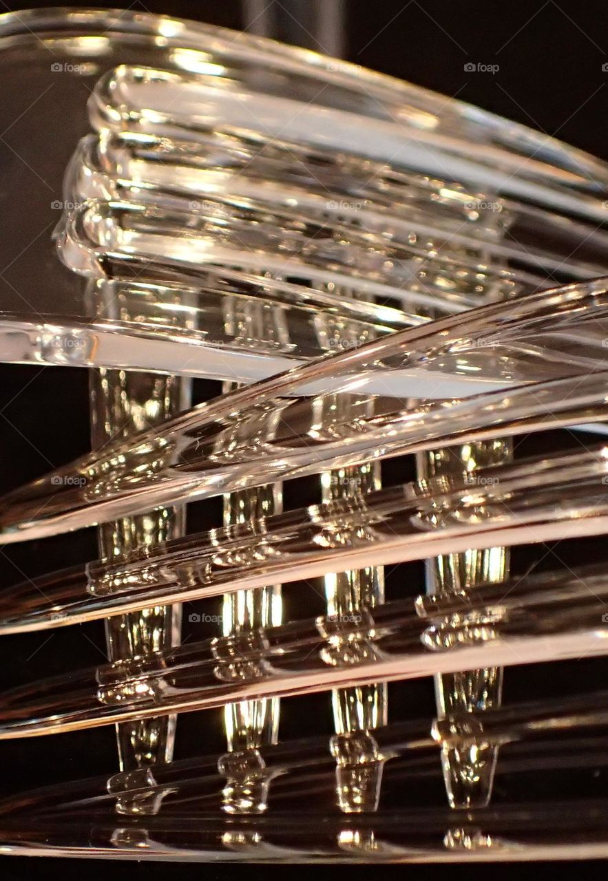 Closeup of three overlapping clear plastic forks against black background 