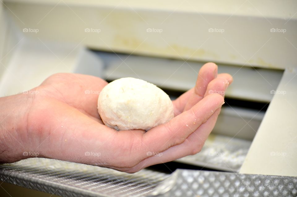 Hand holding pizza dough ball