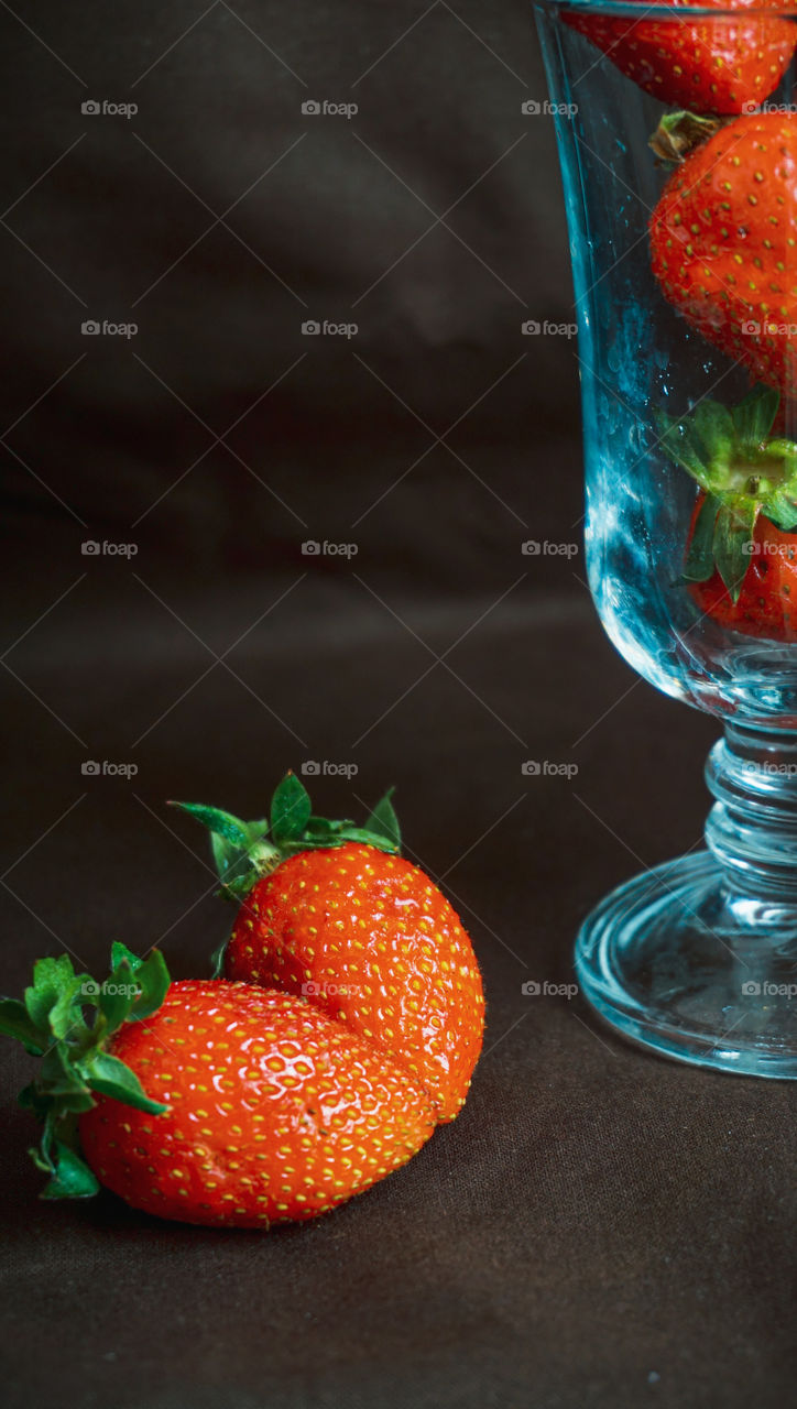 strawberries in a glass on a dark background