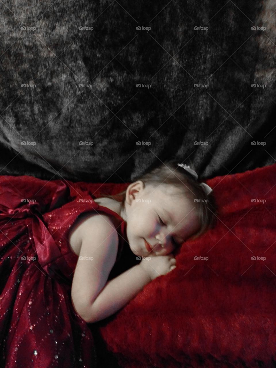 Baby girl in red dress sleeping
