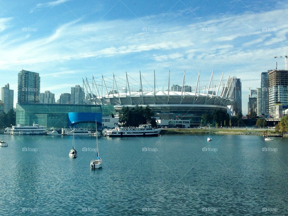 Vancouver harbour looking toward BC Place, Vancouver British Columbia, ocean harbour with yachts, ferries, buildings across the water 