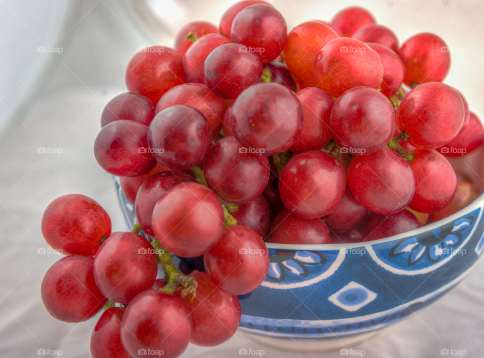 Bowl of fresh red grapes. Bunch of red grapes and a ceramic bowl