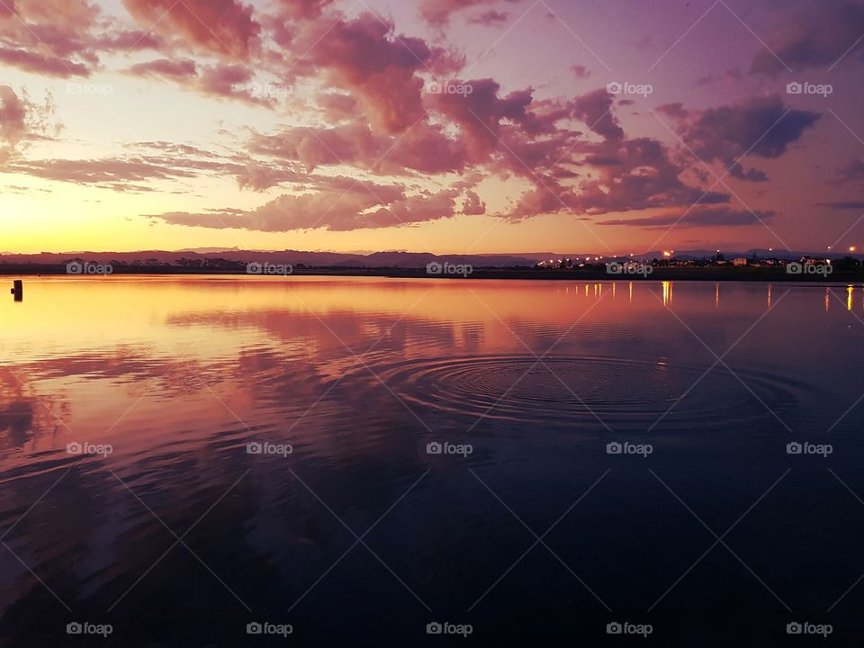 Pandora Ponds beautiful sunset that mirrors off the water with a lovely splash ripple stunning with sunshine setting colors.