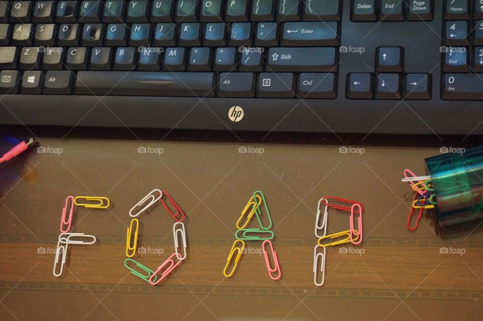 Foap in paper clips . Photo taken of desk from above.  Features colorful paper clips spelling FOAP.