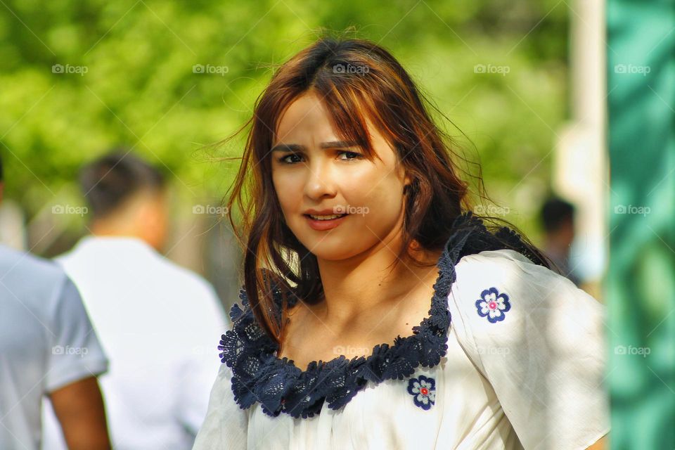 girl with smooth skin from Uzbekistan against a background of trees