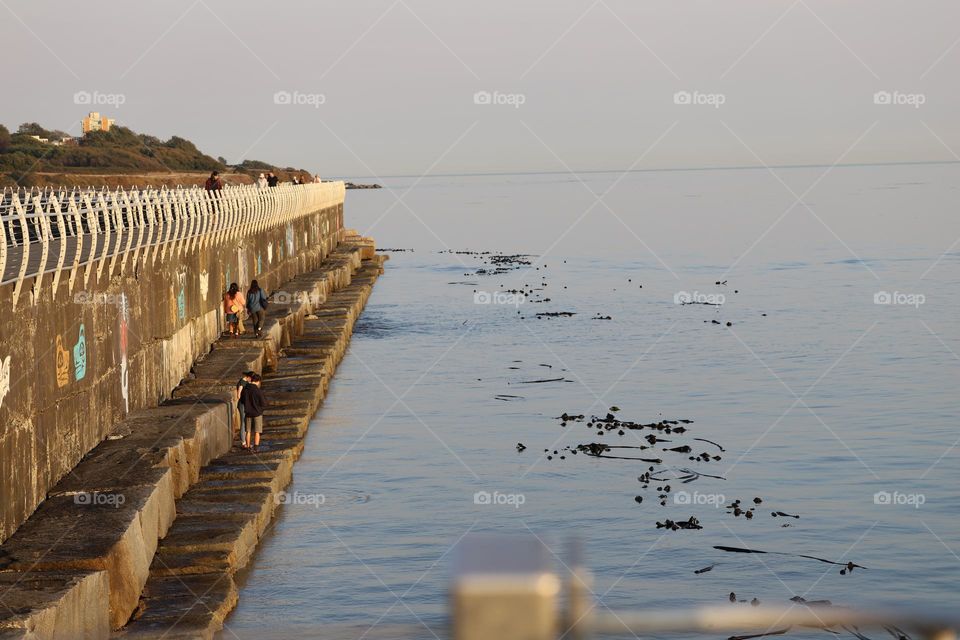 People walking on breakwater 