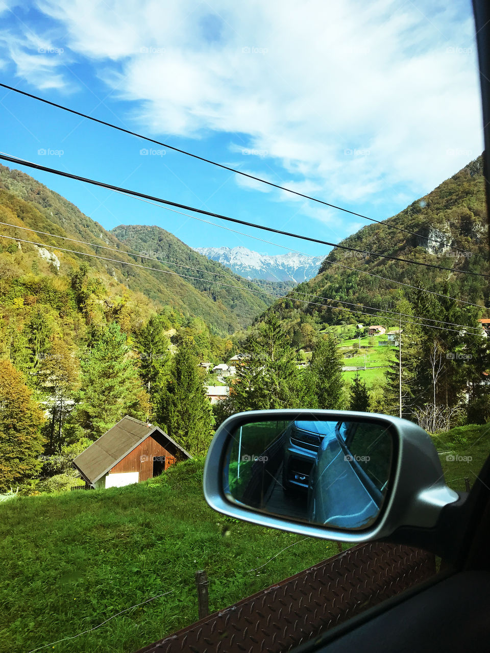 autumn road train trip to the Slovenian Alps mountains. Scenic view to green mountains against blue sky from our window in car.