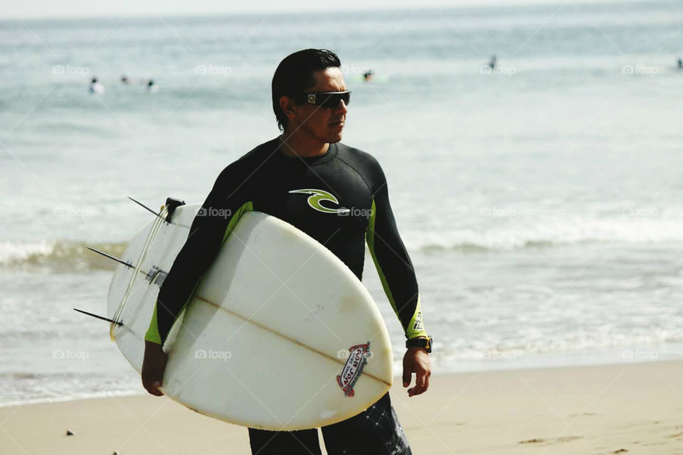 Man holding a surfboard on beach