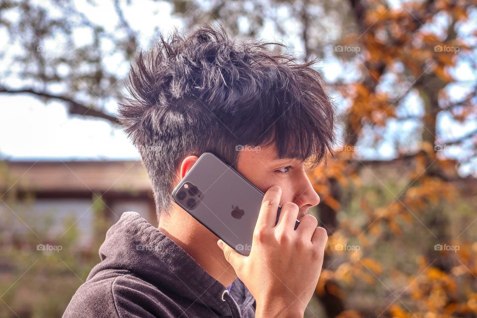 Handsome young man is talking on his Apple phone