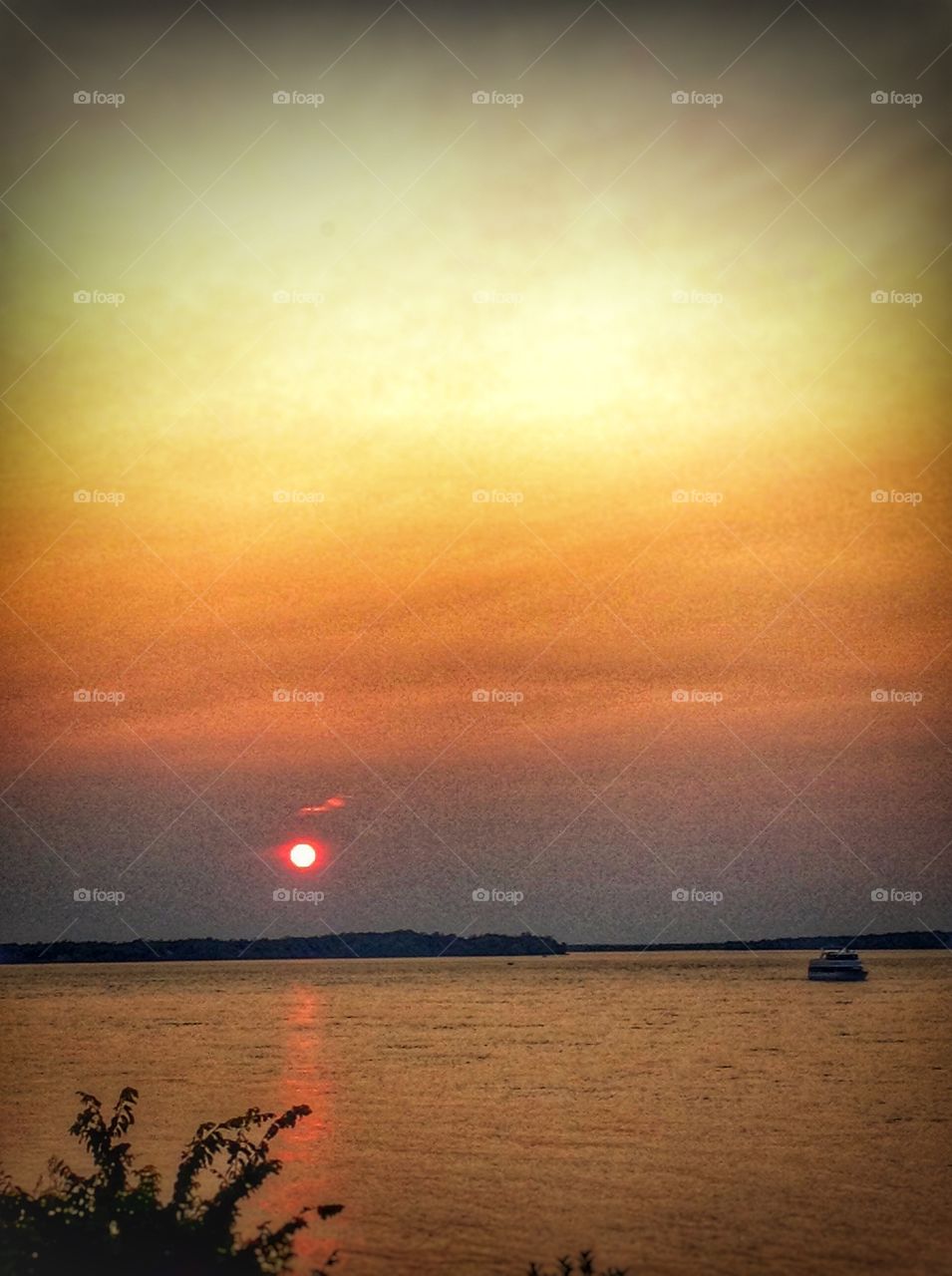 Sunset cruise . A red tint sun setting on Niagara river.