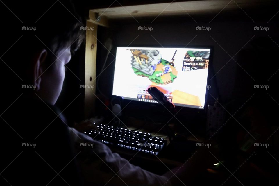 Kid playing Minecraft in the dark