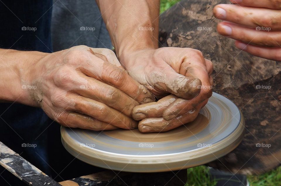 man making pottery out of clay