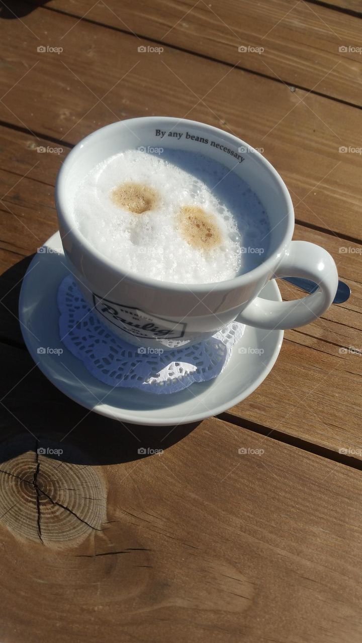 A cup of coffee outside on a sunny spring day.