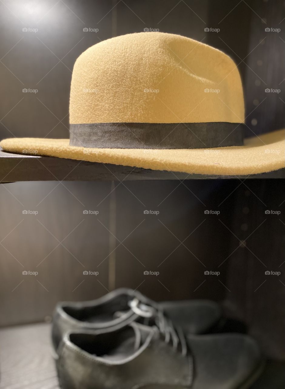 Men's hat exposed with black shoes
