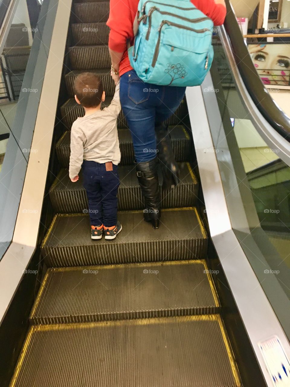 Mother and child go up the escalator