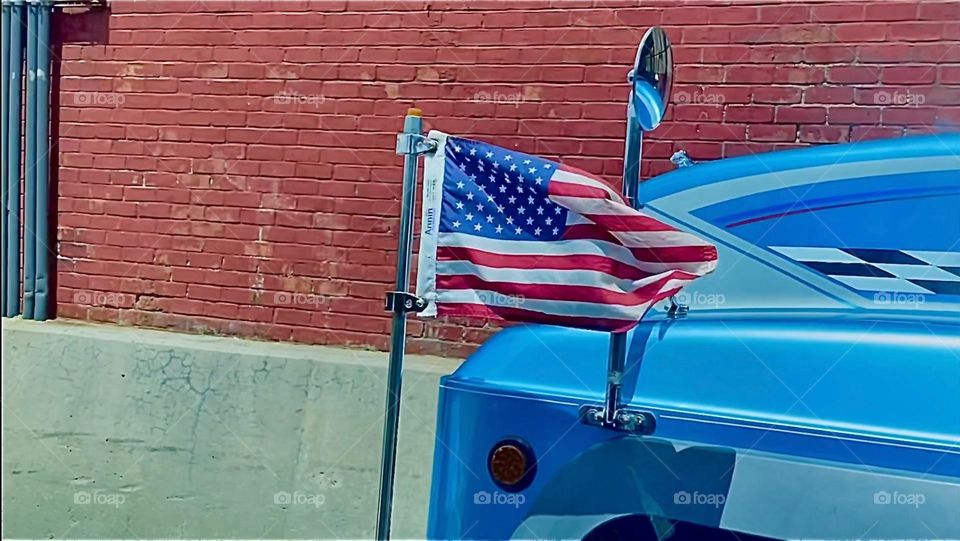Further stills from the red white and blue „Star Spangled Banner“ in motion attached to a whimsical and old fashioned looking car with odd details found somewhere along „Borden Ave“ in LIC, Queens, NY. 2022. Hypnotic Productions