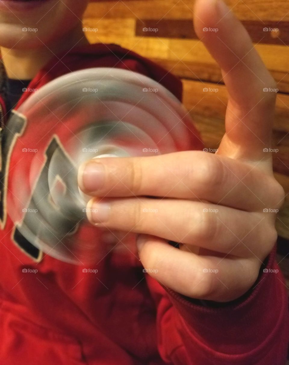 boy playing with fidget spinner, long exposure