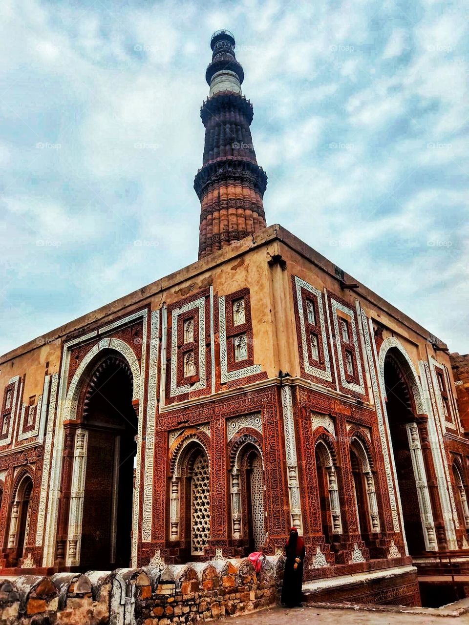 Wow, that tower is super tall! It makes the person standing in front of it look tiny in comparison. It's like a real-life fairy tale scene! π°π€