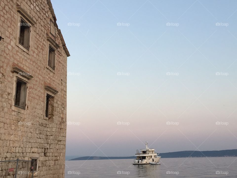 Hidden Dalmatia. An old ruined house in Dalmatia, the southern region of Croatia and a modern yacht in the Adriatic Sea