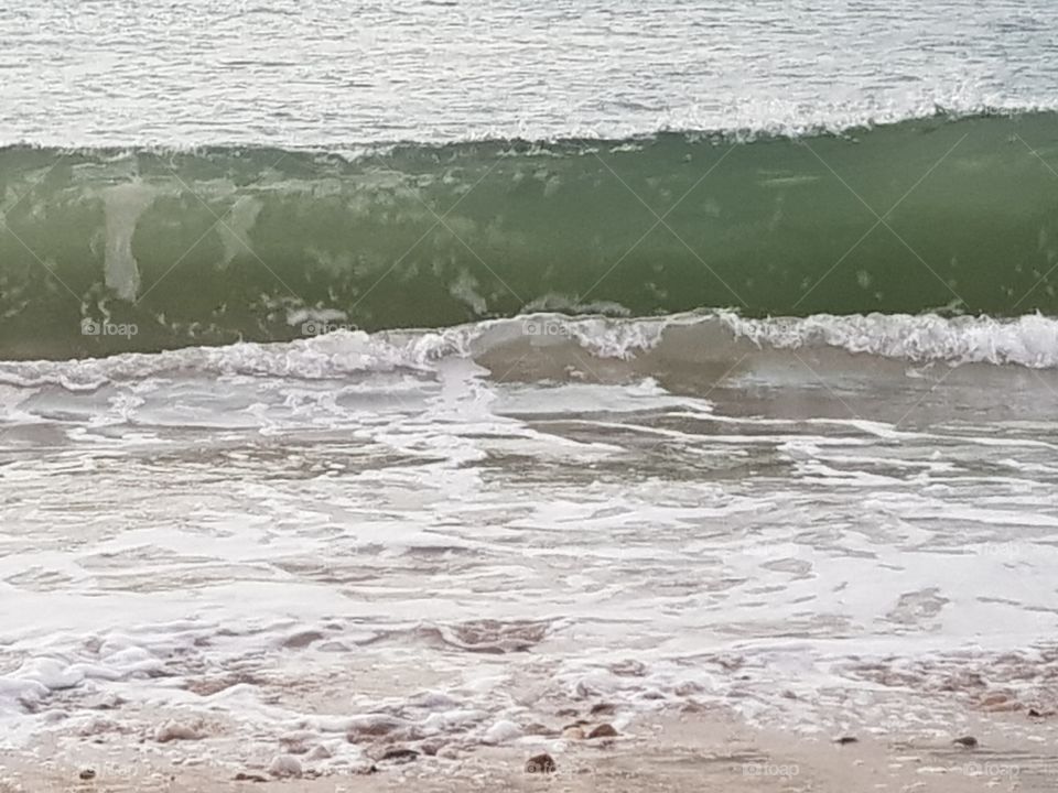 A small wave from the sea that washes up.