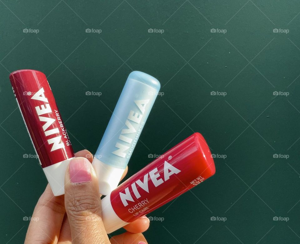 Holding Nivea lip balms 