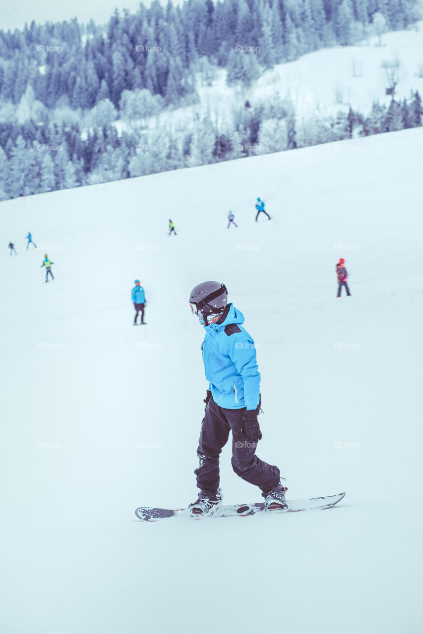 Boy riding a snowboard down the slope
