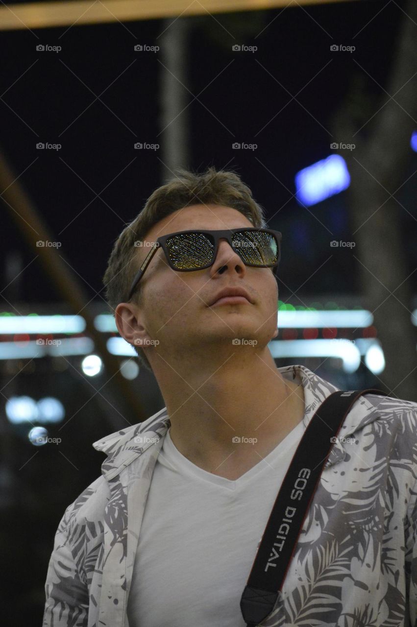 guy with glasses in the evening against the dark sky