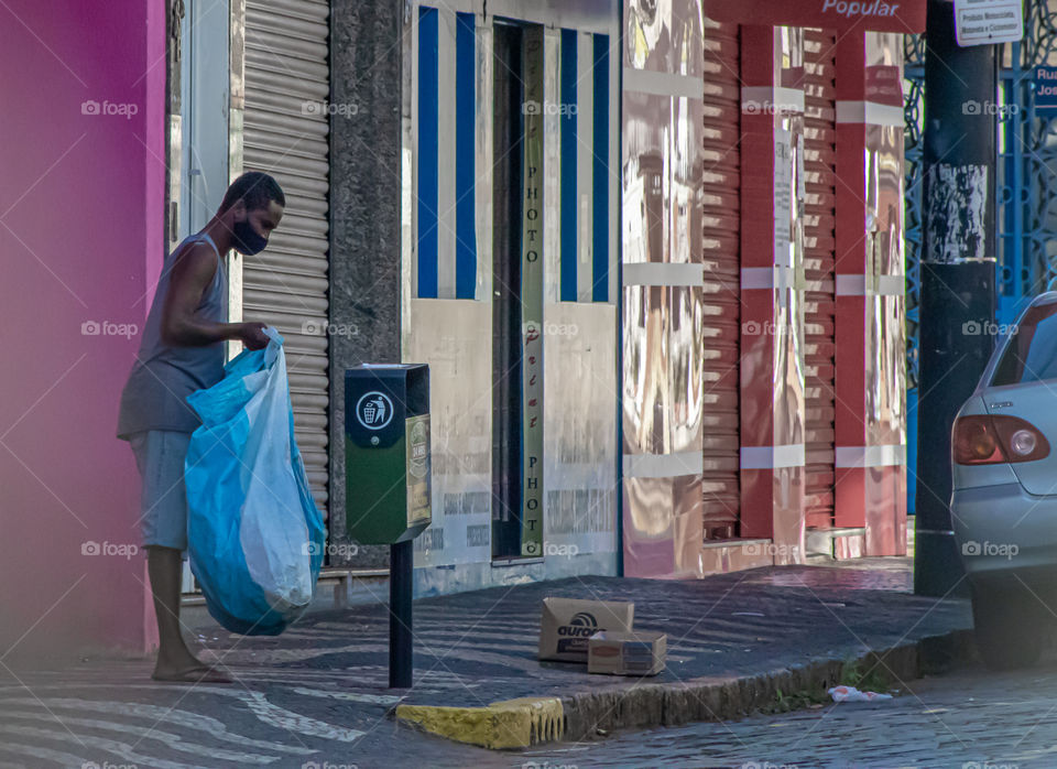 Jovem reciclando o lixo em tempo de pandemia.