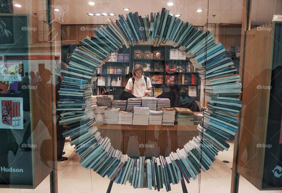 A circular arrangement of books taken through a window 📚