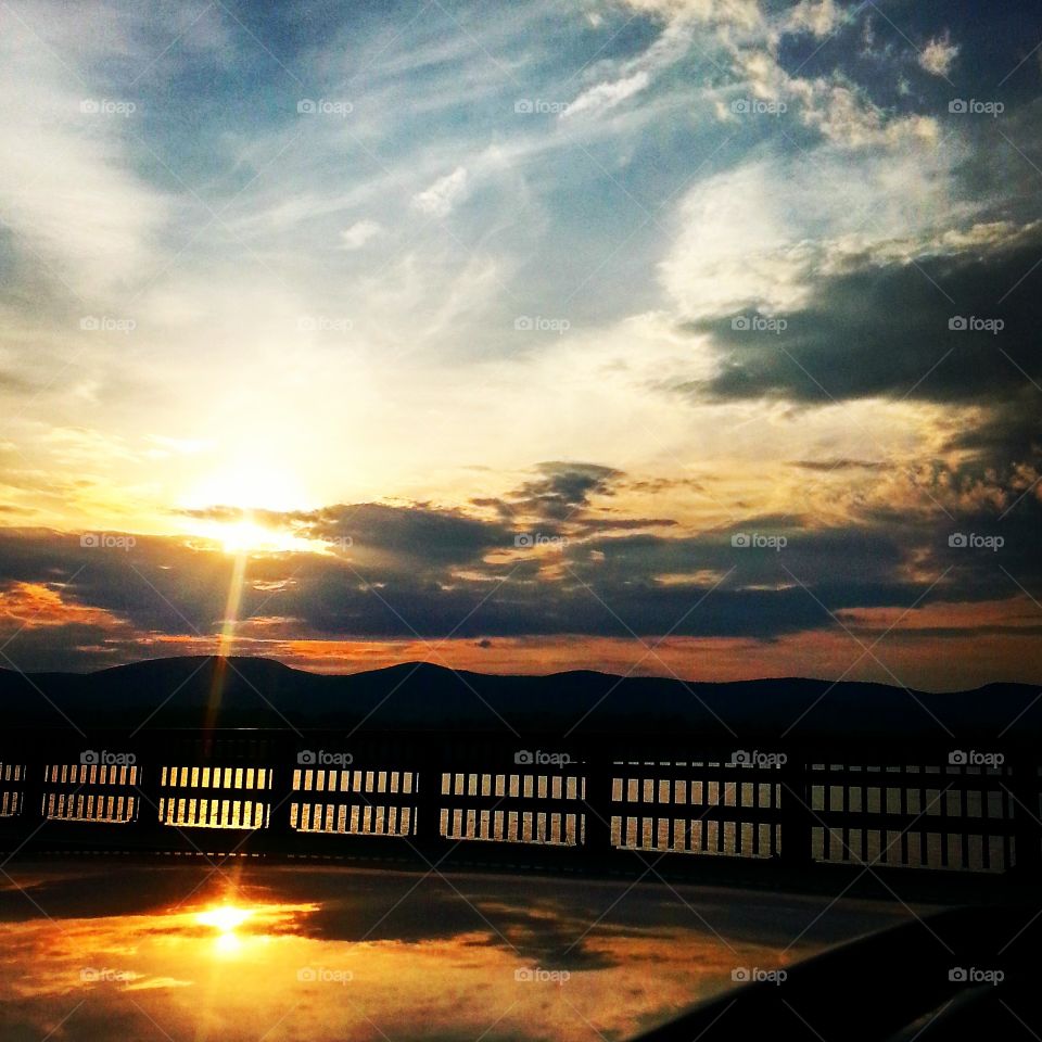 Reflection of a sunset with mountains and clouds