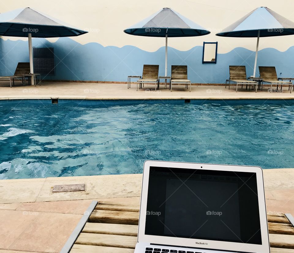 Working at the pool with a laptop
