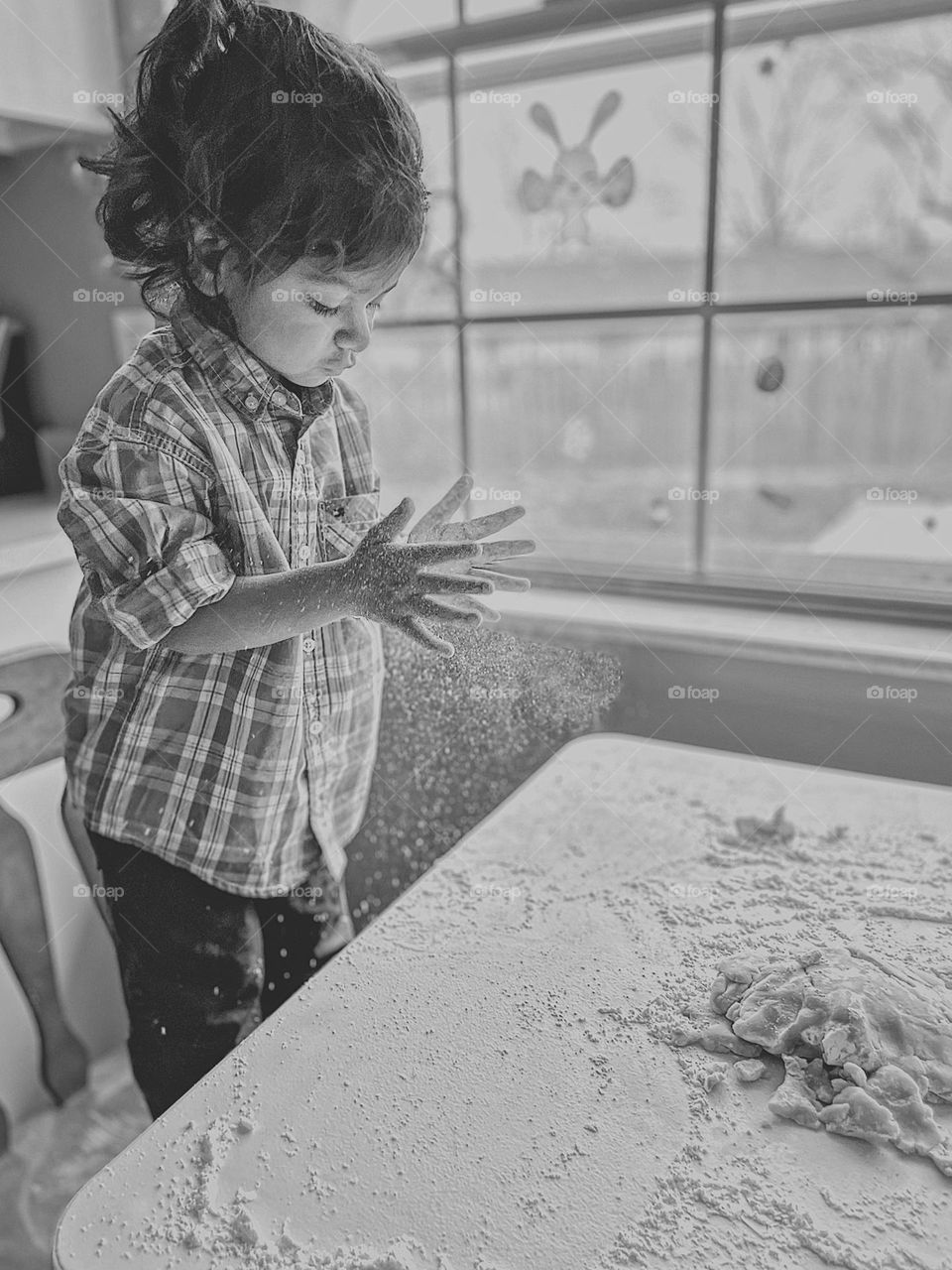 Toddler girl claps hands with flour, making sugar cookies with toddlers, baking with children, black and white portraits, emotional imagery with monochrome, details in black and white