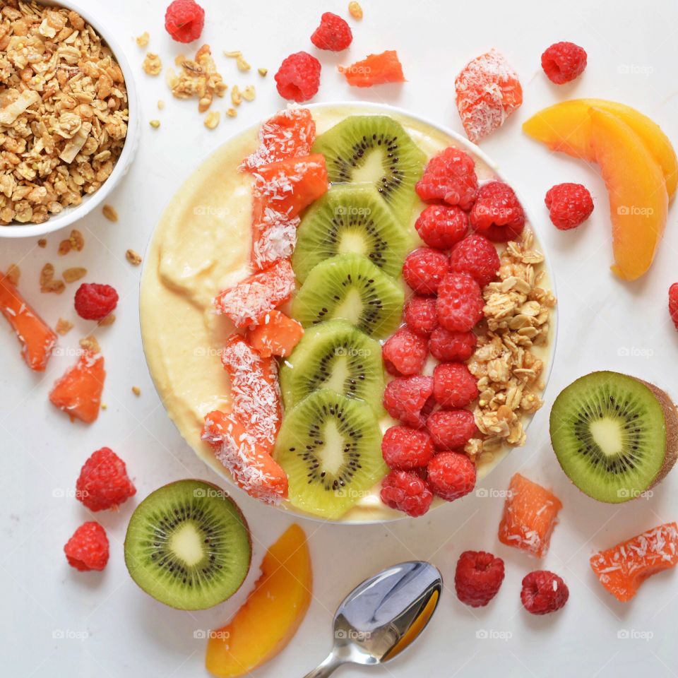 Smoothie Bowl. Peach Pineapple Mango Smoothie topped with fresh fruit 