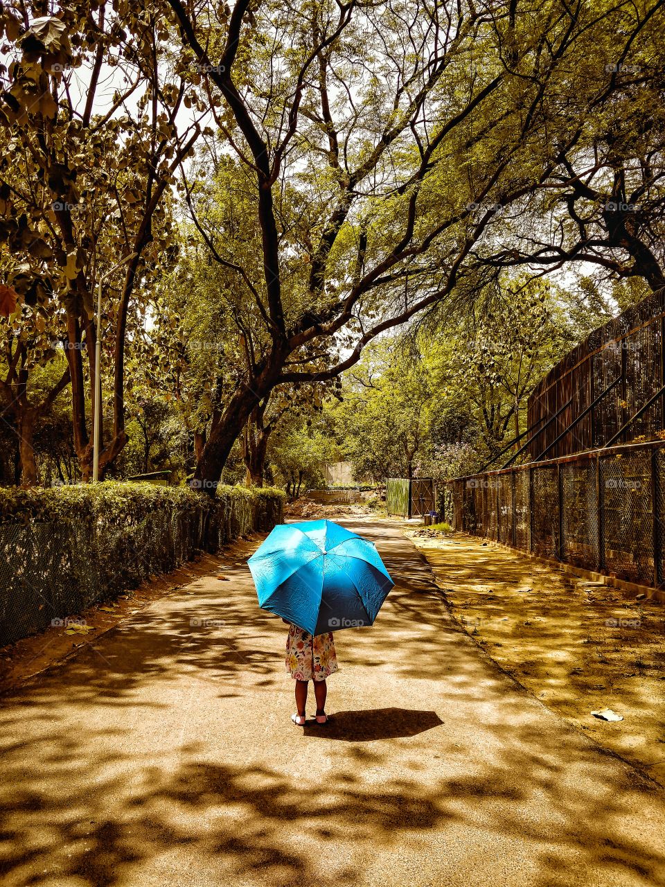 a girl standing under umbrella in very hot day during travelling