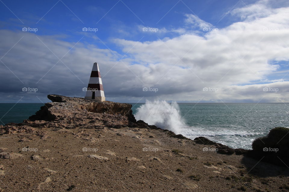 Obelisk on cliff with wave crashing, Robe, South Australia