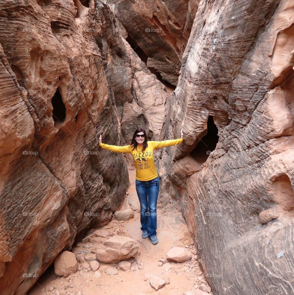 Young woman standing between canyon