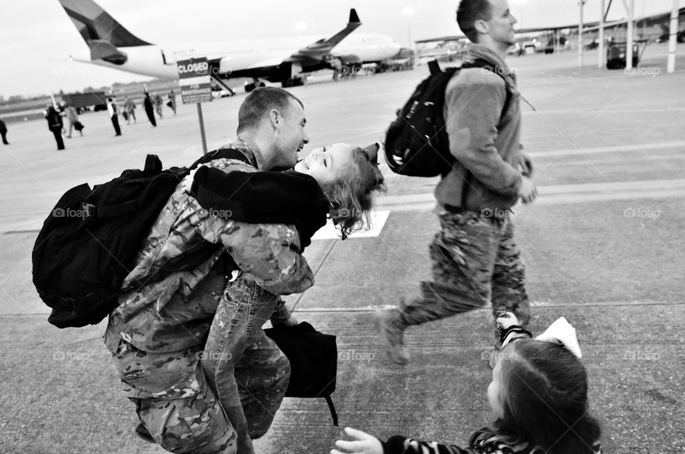 Happy soldier hugging his cute daughter