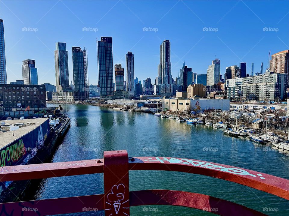 This is „Newtown Creek“ seen from the „Pulaski Bridge“ that connects „Greenpoint“, Bklyn to LIC, Queens. Across the water of the „East River“ you can see LIC and further remote „Manhattan“. 2024. Hypnotic Productions