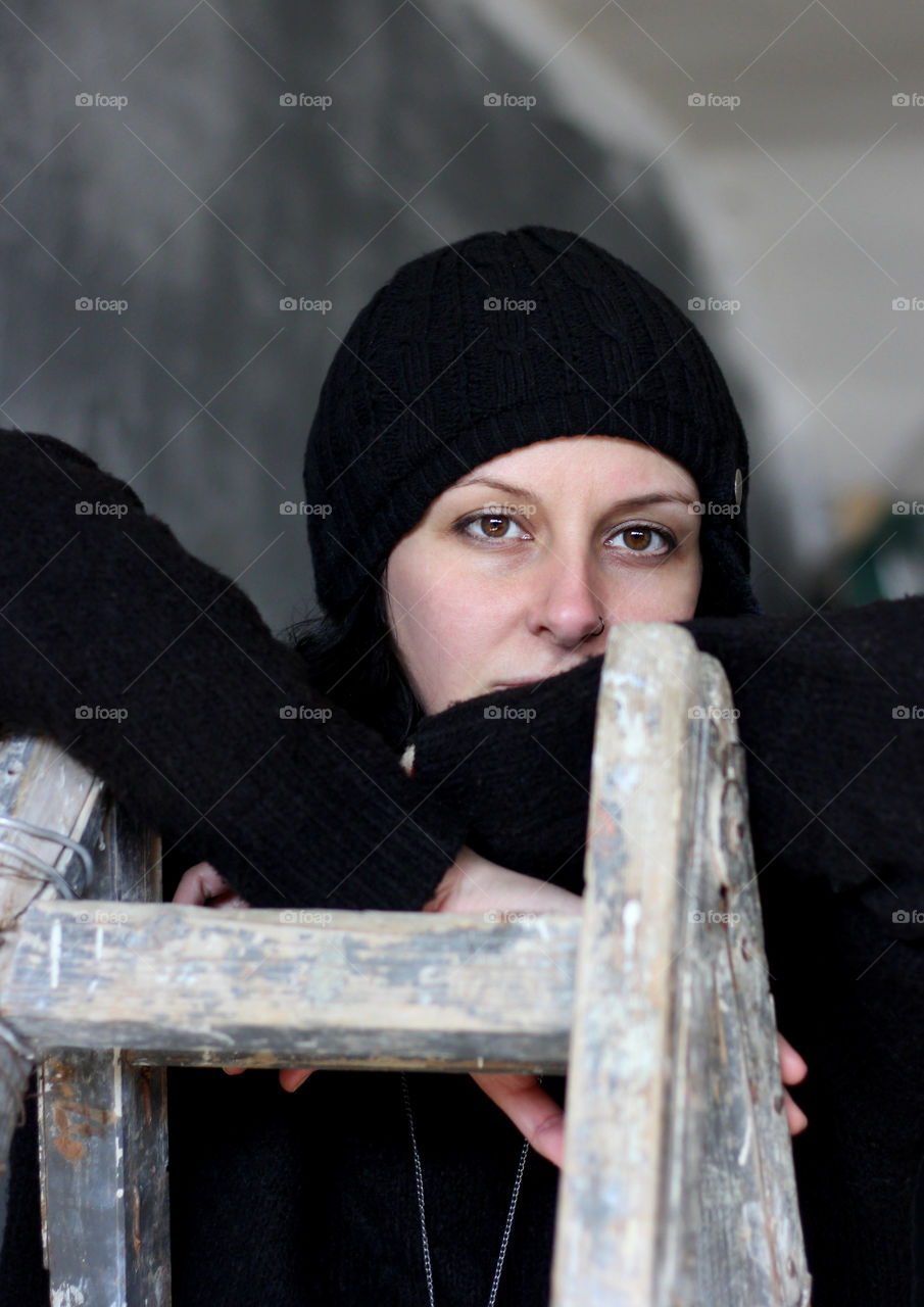 A woman in black on wooden ladder, close up portrait